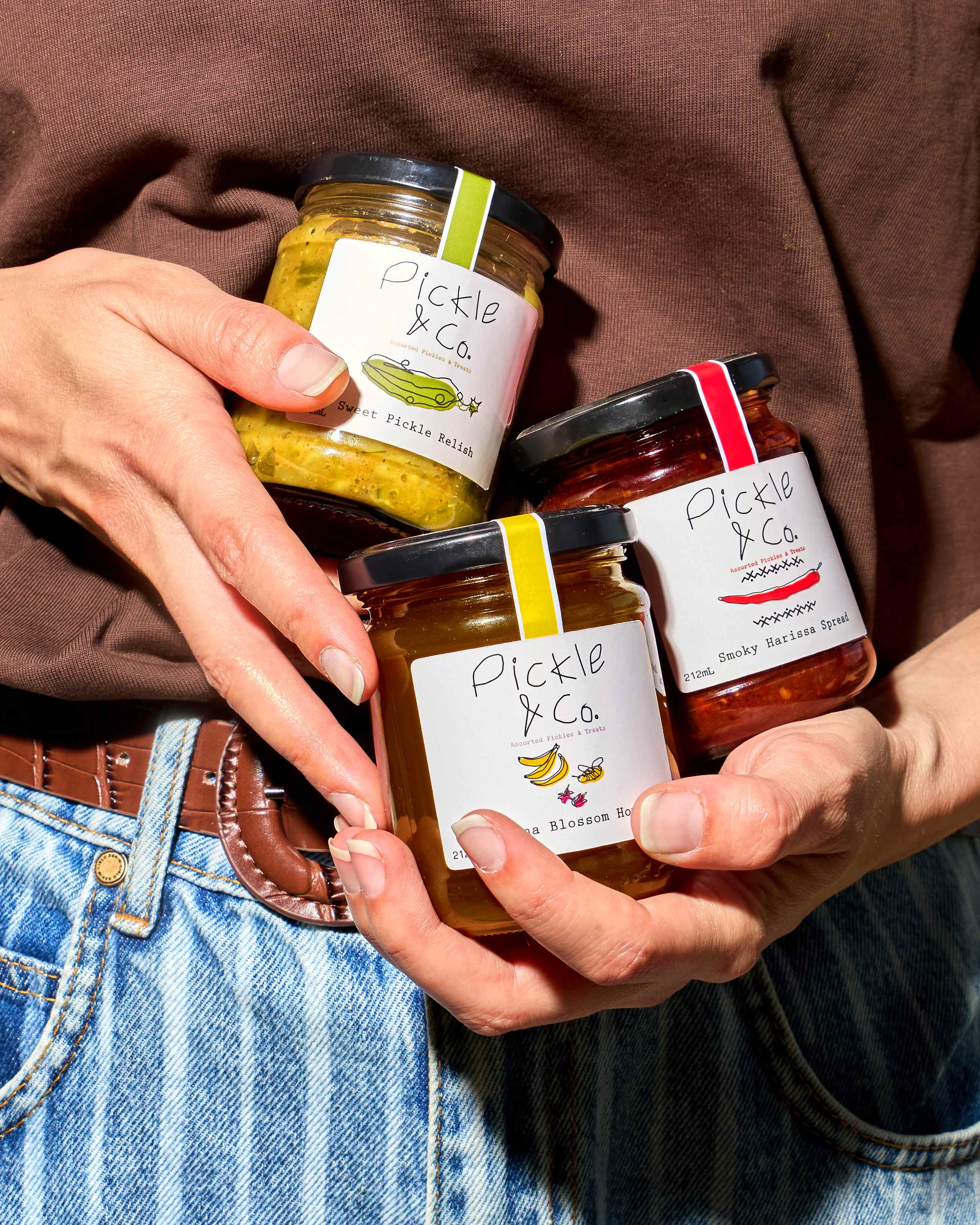 Jars of freshly made pickles on a wooden kitchen table